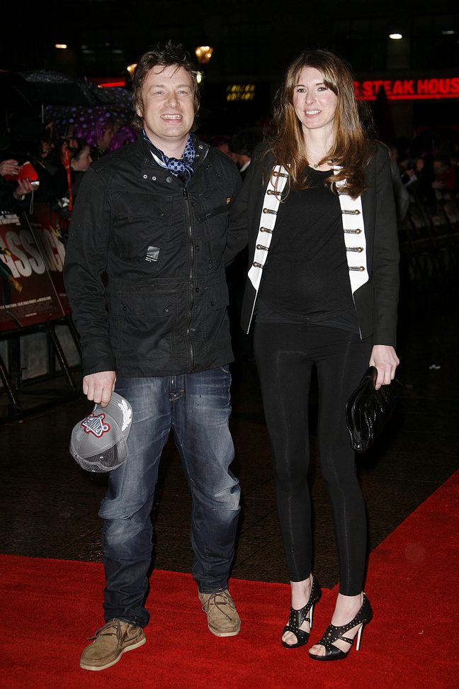 Jamie Oliver, Jools Oliver, black jacket, jeans, baseball hat, black heels, black pants, black jacket